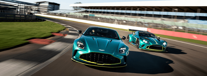 Two green race cars driving side by side on a racetrack